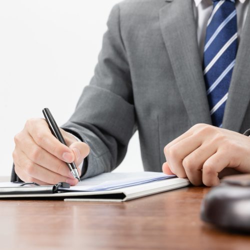 A closeup shot of a businessman signing some official papers